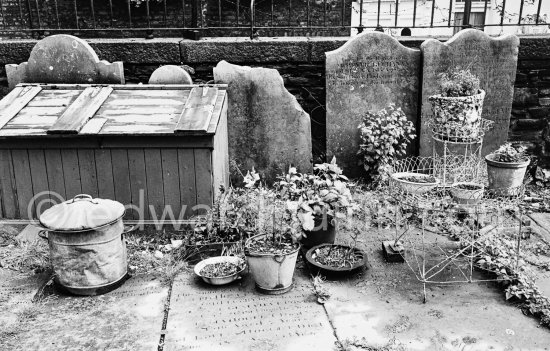 A disused graveyard in the garden of a building at Molesworth Street. Dublin 1963. Published in Quinn, Edward. James Joyces Dublin. Secker & Warburg, London 1974. - Photo by Edward Quinn