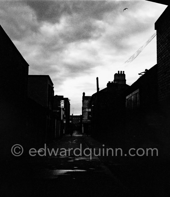 A threatening sky over a Dublin City lane. Dublin 1963. Published in Quinn, Edward. James Joyces Dublin. Secker & Warburg, London 1974. - Photo by Edward Quinn