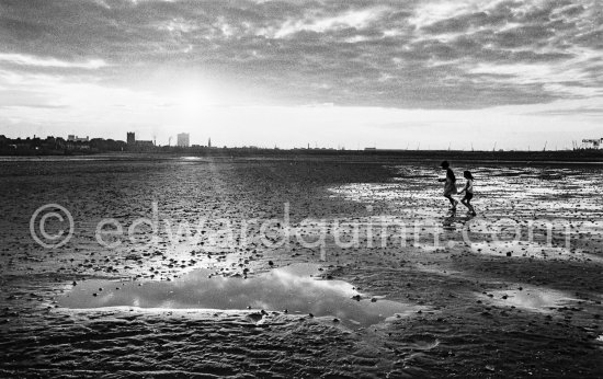 Children playing on the Sandymount Strand. Dublin 1963. Published in Quinn, Edward. James Joyces Dublin. Secker & Warburg, London 1974. - Photo by Edward Quinn