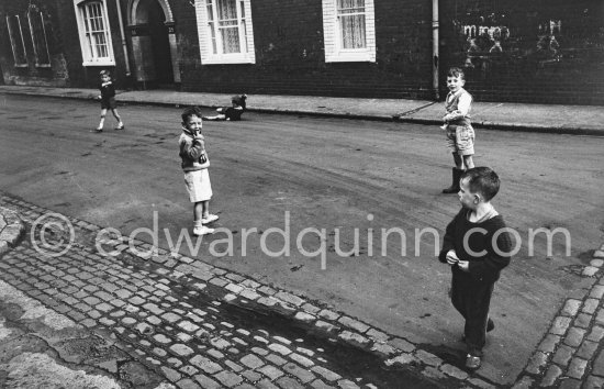 Children playing. Tenement houses at the corner of Moss Street and Gloucester Street south. Dublin 1963. - Photo by Edward Quinn