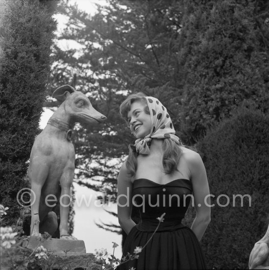Brigitte Bardot posing with a dog sculpture. Cannes Film Festival 1953. - Photo by Edward Quinn