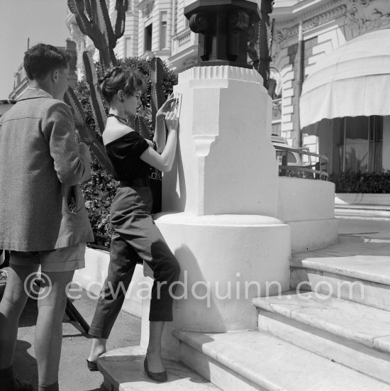 Brigitte Bardot signing a set card. Cannes Film Festival 1956. - Photo by Edward Quinn