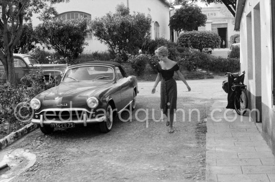 Brigitte Bardot just getting famous, offering a charming smile to – her new cabriolet. BB did advertising for Simca. Nice 1956. Cars: 1955 or 56 Simca Aronde Week-end. 1955-57 Vélosolex 660 on the right, Peugeot 203 in the background. - Photo by Edward Quinn