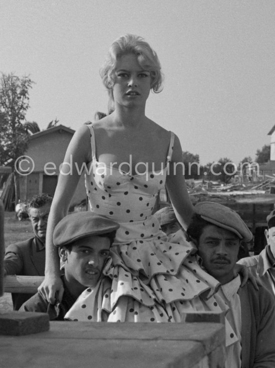 Brigitte Bardot during filming of the last scenes of "Les Bijoutiers du clair de lune" ("The Night Heaven Fell"), on the grounds of the Studios de la Victorine in Nice. Directing the film is Brigitte’s ex-husband Roger Vadim. Brigitte is carried by two Romani. The scene is supposed to represent Brigitte being carried victoriously out of the bull ring, after having given battle to a bull. All people in the back, young and old, are Romani. Nice 1958. - Photo by Edward Quinn