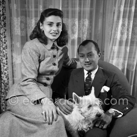 Prince Bira of Siam, the only Thai race car driver to race in Formula One, with his wife Chelita and his West Highland Terrier Titch. Cannes 1954. - Photo by Edward Quinn