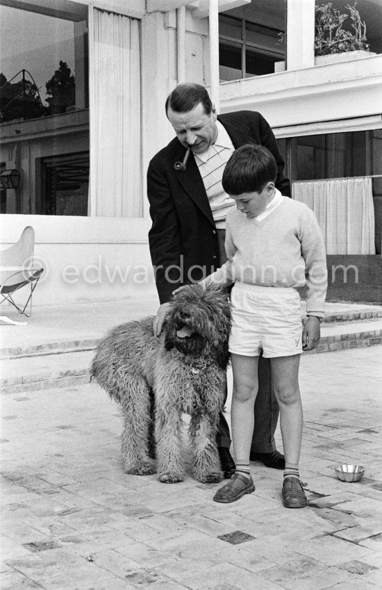 Georges Simenon with his poodle Mister and Charlie Chaplin\'s son Michael at his Villa Golden Gate. Cannes 1955. - Photo by Edward Quinn