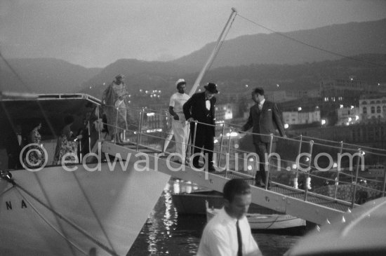 On several occasions Sir Winston Churchill was a guest on the Onassis yacht Christina anchored in the harbor of Monaco. Out for a dinner party, walking down the gangplank is Edmond Murray, Churchill’s Scotland Yard body guard. He is preceeding Sir Winston, followed by a sailor. At the top of the gangplank is Lady Churchill. Monaco 1959. - Photo by Edward Quinn