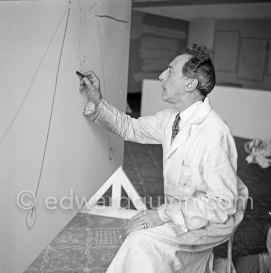 Jean Cocteau, making a drawing for the 6th Cannes Film Festival. Cannes 1953. Cartier Trinity. - Photo by Edward Quinn