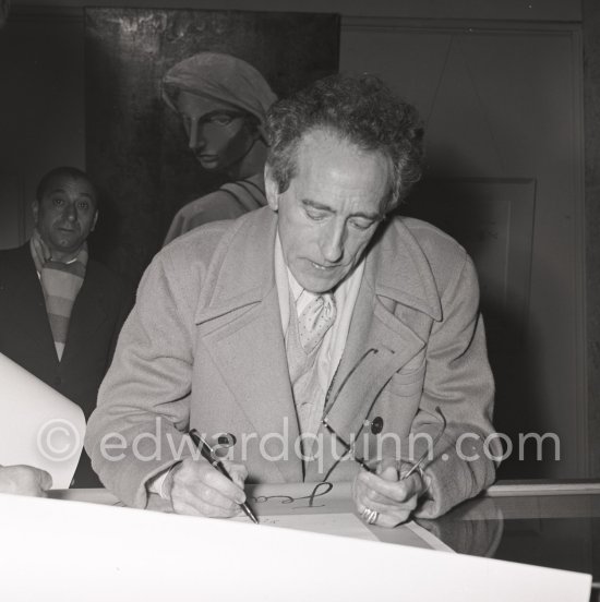 Jean Cocteau in the Galerie des Ponchettes dedicating a catalogue, Nice where there is an exhibition of his paintings. With two Cartier Trinity rings. 10th February 1953. - Photo by Edward Quinn