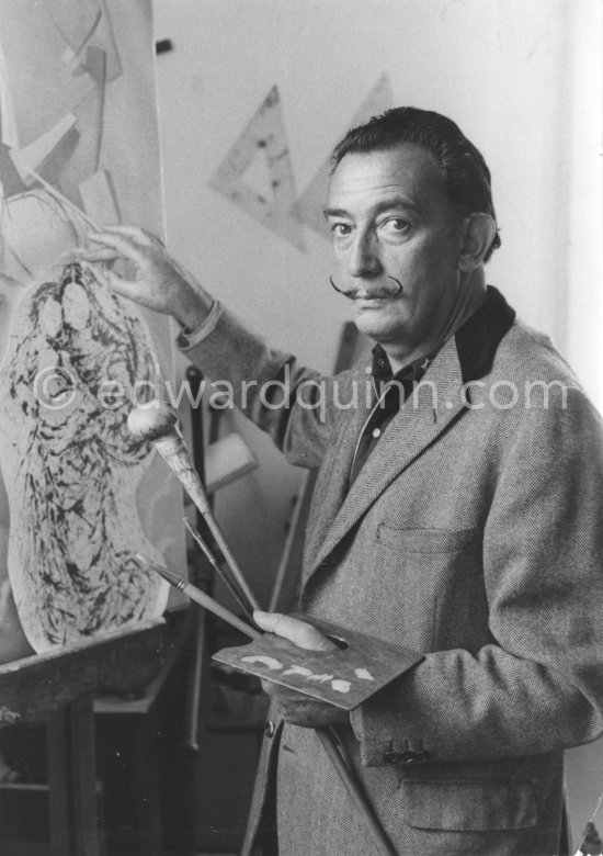 Salvador Dalí poses at his studio with his ink drawing of a madonna and her child and the painting "Cosmic Madonna", finished in 1958. At Salvador Dalí\'s house, Portlligat, Cadaqués, 1957. - Photo by Edward Quinn