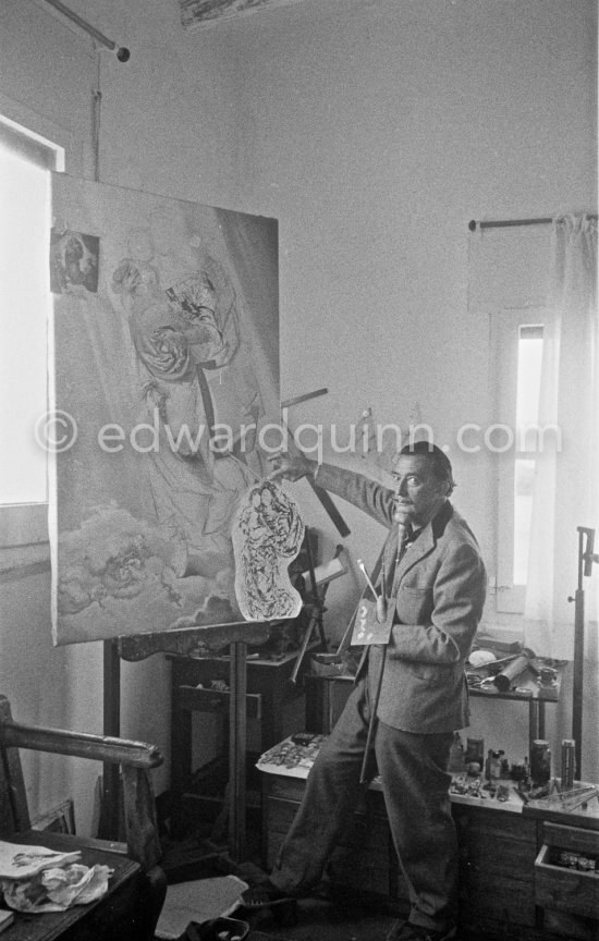 Salvador Dalí poses at his studio with his ink drawing of a madonna and her child and the painting "Cosmic Madonna", finished in 1958. At Salvador Dalí\'s house, Portlligat, Cadaqués, 1957. - Photo by Edward Quinn