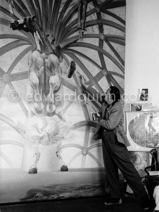 Salvador Dalí and his oil painting "Santiago El Grande", featuring a rearing white horse with St. James of Compostela, the patron saint of Spain, on its back. Portlligat, Cadaqués, 1957. - Photo by Edward Quinn