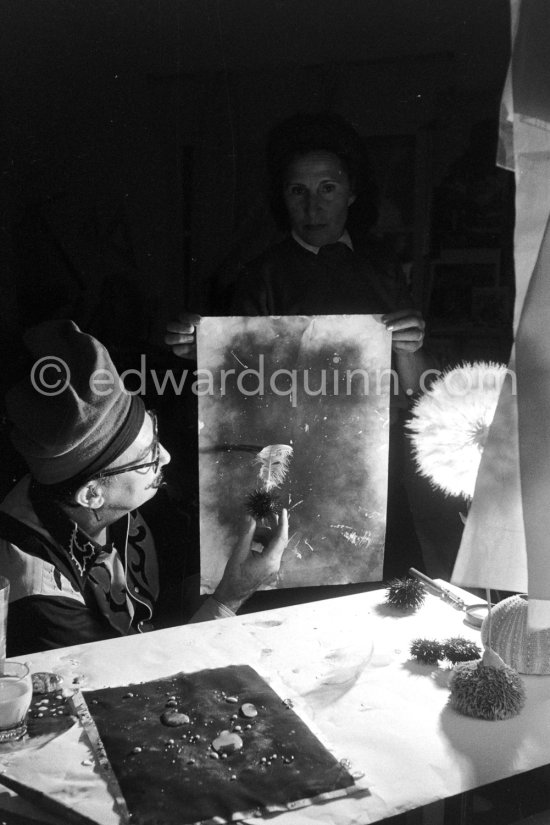 Watched by his wife Gala, Salvador Dalí works on his experiments with the sea urchin holding a swan feather and moving backwards and forewards thus marking the blackened paper. These experiments he is carrying out at his studio in his Spanish home at Portlligat, Cadaqués, on the Costa Brava 1957. - Photo by Edward Quinn