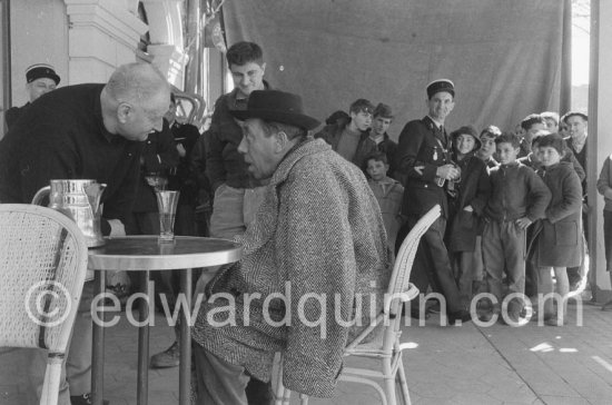 Jean Giono (on the left) wrote and directed the film "Crésus". Fernandel (sitting) starred in the film. A policeman and schoolchildren were pleased to see the famous Fernandel himself. Manosque 1960. - Photo by Edward Quinn