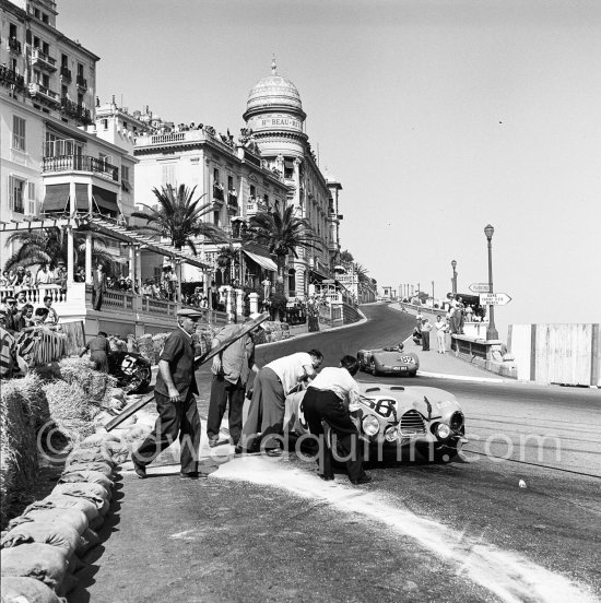 The accident at Sainte-Dévote: Robert Manzon, (56) Simca Gordini T15S, Reg Parnell, (72) Aston Martin DB3, Wisdom, (82) Jaguar-C. Monaco Grand Prix 1952, transformed into a race for sports cars. This was a two day event, the Sunday, Prix Monte Carlo, for the up to 2 litres (Prix de Monte Carlo), the Grand Prix, Monday for the bigger engines, (Monaco Grand Prix). The Aston engine of Parnell blows up in the Ste-Devote and aligns his car against the straw bales, Stagnoli brakes too hard and does a double spin. Moss, Jaguar C-Type XKC 003 and Manzon find an obstructed road, spin and end up against the poor Aston, then Hume spins and reverses into the pile. Fortunately nobody gets hurt. Moss restarted after the accident, but got a black flag for receiving outside help. - Photo by Edward Quinn