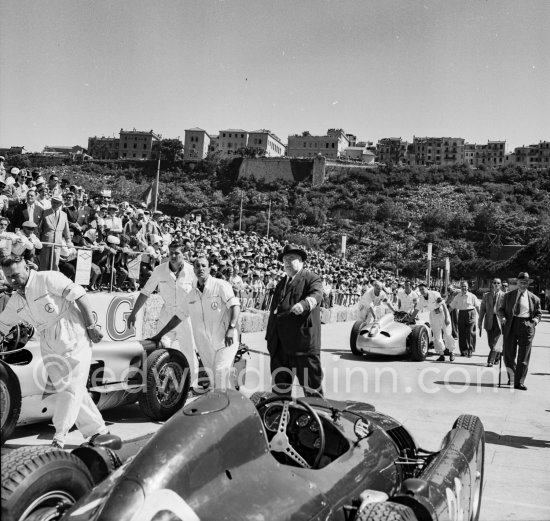 Alfred Neubauer, Mercedes racing manager. The cars of Ascari, (26) Moss, (6) Mercedes-Benz W196 and Fangio, (2) Mercedes-Benz W196. "Le Rocher" in the background. Monaco Grand Prix 1955. - Photo by Edward Quinn