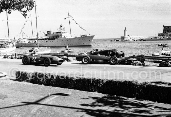 The cars of Mike Hawthorn, (28) Ferrari-Lancia D50 and Peter Collins, (26) Ferrari 801 in the barriers while Juan Manuel Fangio, (32) Maserati 250F passes. Yacht Trenora in the background. The incident happend in lap 4 of the 1957 Monaco Grand Prix after leader Stirling Moss "lost" his Vanwall in the chicane. Peter Collins swerved to avoid Moss but hit the wall while Mike Hawthorn rammed Tony Brooks who braked hard to avoid the cars in front of him. - Photo by Edward Quinn