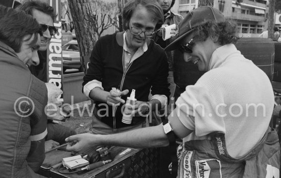 Before one of the trial runs, Niki Lauda\'s doctor gave him an injection and made a blood test. Laude rarely smiles, but submitted to this good humouredly. Monaco Grand Prix 1978. - Photo by Edward Quinn
