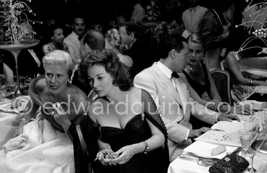 Susan Hayward and Ginger Rogers in animated conversation at Cannes Film Festival. Behind them Ingrid Bergman and the Cannes Festival founder and president Robert Favre Le Bret. During the closing gala dinner. Cannes 1956. - Photo by Edward Quinn