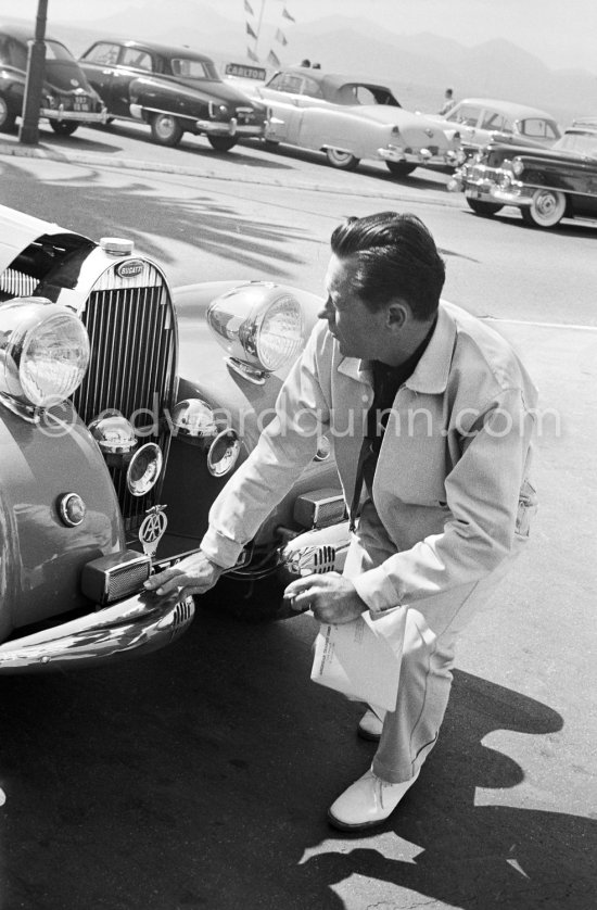 William Holden, an ardent car enthusiast, admires the vintage car of Sir Duncan Orr Lewis. Cannes 1957. Car: Bugatti type 57C Aravis Gangloff chassis number 57736. - Photo by Edward Quinn