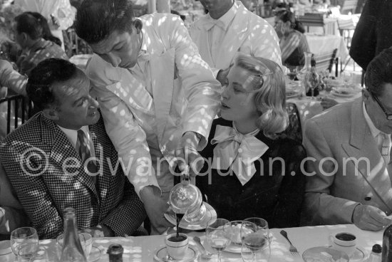 A cup of coffee for Grace Kelly at the Cannes Film Festival. On the left Rupert Allan. Cannes 1955. - Photo by Edward Quinn
