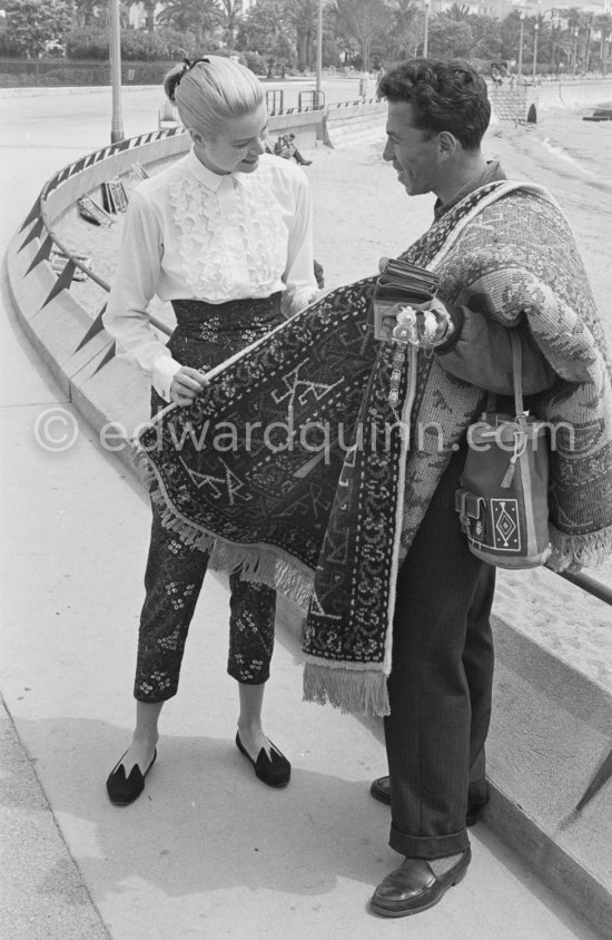 Grace Kelly and a street vendor. Cannes Film Festival 1955. - Photo by Edward Quinn