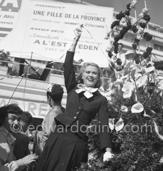 Grace Kelly at the battle of flowers. In front of the poster for "The Country Girl" ("Une fille de la province"). Grace won an Oscar for her role in this film. Cannes Film Festival. Cannes 1955. - Photo by Edward Quinn