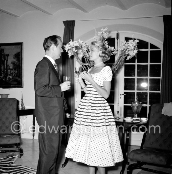 Grace Grace Kelly with celebrity promoter Earl Blackwell at a cocktail party given by Jacques Fath at his home "Moulin de Joko". Cannes 1954. - Photo by Edward Quinn
