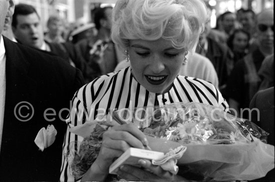 When Jayne Mansfield came to the Cannes Film Festival in 1958, she had just married Mickey Hargitay, the ex-muscle man in Mae West’s nightclub act and former Mr. Universe. From the moment of her arrival at Nice Airport, Jayne had to fight her way through a crowd of fans and journalists. Nice Airport 1958. - Photo by Edward Quinn