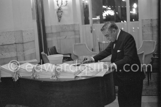 Aristotle Onassis studying the program, at a charity gala for refugees organized by Prince Sadruddin Khan. Hotel de Paris, Monaco 1963. - Photo by Edward Quinn