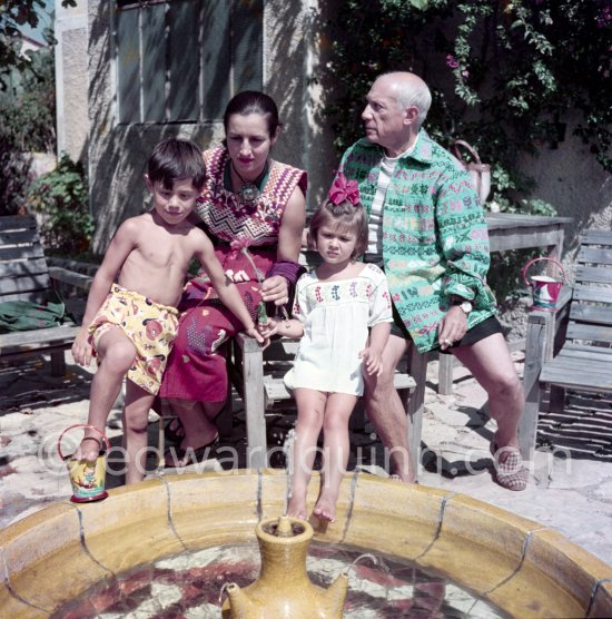 Pablo Picasso, Françoise Gilot and their children Claude Picasso and Paloma Picasso in the garden of La Galloise. Françoise Gilot with a pendant by Pablo Picasso. Vallauris 1953. - Photo by Edward Quinn