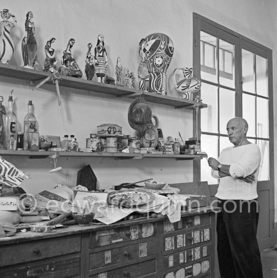 Pablo Picasso in front of a board with his ceramics. Le Fournas, Vallauris 1953. - Photo by Edward Quinn