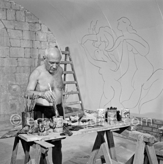 Picasso working on the "War and Peace study" drawings on the wall of Chapelle de la Paix (or Temple de la Paix) for the documentary film of Luciano Emmer. (The panels of War and Peace of 1952 were away on exhibition). Vallauris 1953. - Photo by Edward Quinn