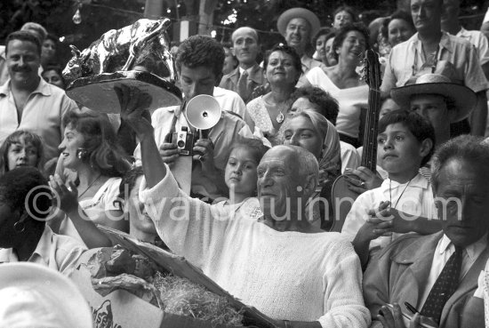 Pablo Picasso on the grandstand at the corrida with a bull sculpture, a present from the bullfighters ("A notre camarade Pablo Picasso, Section Vallauris, Corrida 1955."). Jacqueline, Maya Picasso, Claude Picasso, Paloma Picasso, Jean Cocteau, Francine Weisweiller. Vallauris 1955. - Photo by Edward Quinn