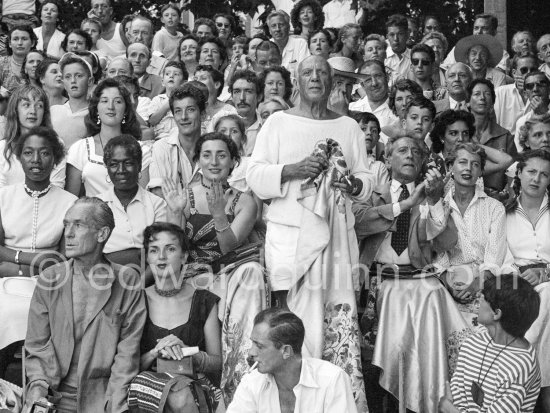 On the grandstand of a bullfight put on in Pablo Picasso\'s honor. On the left of Pablo Picasso Jacqueline, on the right Jean Cocteau, Inès Sassier, Pablo Picasso\'s housekeeper and Francine Weisweiller and her daughter Carole, behind Pablo Picasso his children Paloma Picasso, Maya Picasso and Claude Picasso, in front on the left photographer Jacques-Henri Lartigue, his wife Florette. Vallauris 1955. - Photo by Edward Quinn