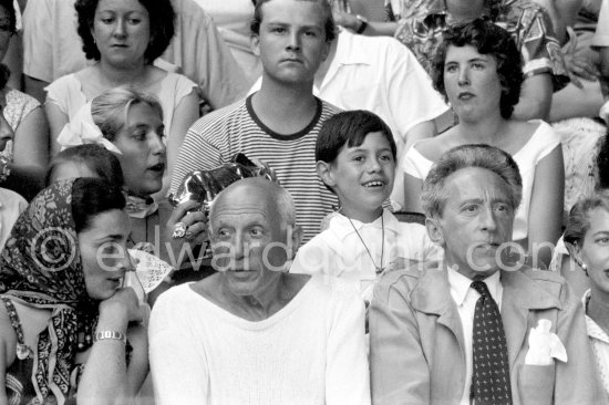 On the grandstand of a bullfight put on in Pablo Picasso\'s honor. On the left of Pablo Picasso Jacqueline, on the right Jean Cocteau, behind Pablo Picasso his children Paloma Picasso, Maya Picasso and Claude Picasso. Vallauris 1955. - Photo by Edward Quinn