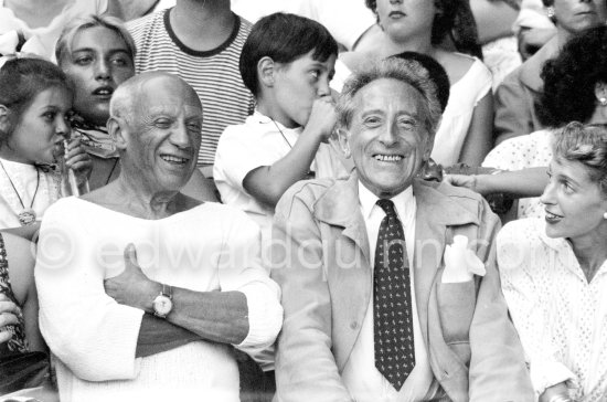 On the grandstand of a bullfight put on in Pablo Picasso\'s honor. From left: Jacqueline, Pablo Picasso, Jean Cocteau and Francine Weisweiller. Behind them Paloma Picasso, Maya Picasso and Claude Picasso. Vallauris 1955. - Photo by Edward Quinn