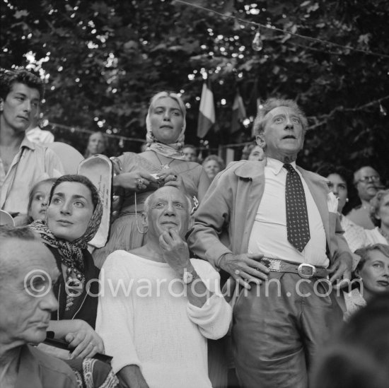 Pablo Picasso on the grandstand at the corrida surrounded by his family and friends. Lartigue, Jacqueline, Maya Picasso, Jean Cocteau, Francine Weisweiller. Vallauris 1955. - Photo by Edward Quinn