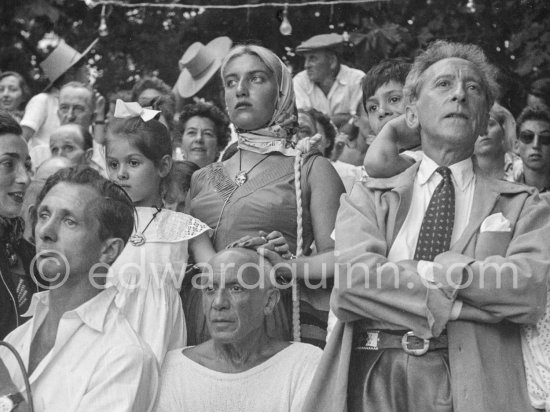 Paloma Picasso, Maya Picasso and Claude Picasso, their hands tenderly laid on their father Pablo Picasso\'s head anxiously watch a bullfight. On the right Jean Cocteau and Gérard Sassier. Vallauris, 1955. Interview RTF by Roger Sadoul: http://www.ina.fr/audio/P13108794/corrida-a-Vallauris-ete-1955.-audio.html - Photo by Edward Quinn