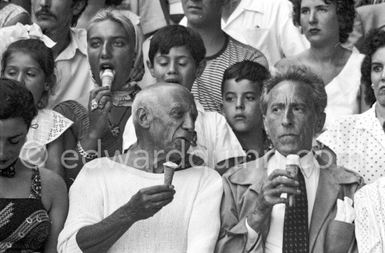 At a local Corrida. During a break, Pablo Picasso and friends refresh themselves with ice cream cornets. Jacqueline, in the background Maya Picasso, Claude Picasso, Paloma Picasso, Jean Cocteau, Francine Weisweiller. Vallauris, 11.8.1955. - Photo by Edward Quinn