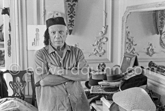 To strike a pose, Pablo Picasso tries on hats from his collection for his own amusement and that of his guests. Here he wears an oriental Fez. La Californie, Cannes 1956. - Photo by Edward Quinn