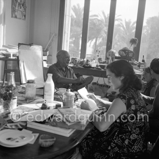 Jacqueline and Pablo Picasso at the dining and work table. Javier Vilató and his wife Germaine Lascaux. Jacqueline is wearing a dress with printed motifs of a Pablo Picasso work. Far right Vilató and his wife. La Californie, Cannes 1956. - Photo by Edward Quinn