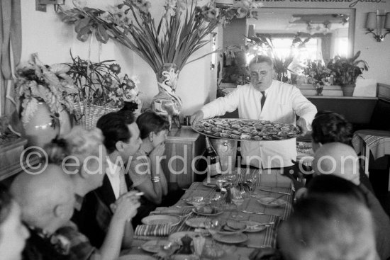 Diner at restaurant Chez Félix. On the occasion of Pablo Picasso\'s 75th birthday 25.10. Pablo Picasso, Hélène Parmelin, Michele Sapone, Germaine Lascaux (Javier Vilató\'s wife). Félix, Anna Maria Torra Amat, wife of Spanish publisher Gustavo Gili, Daniel-Henry Kahnweiler. Cannes 1956. - Photo by Edward Quinn