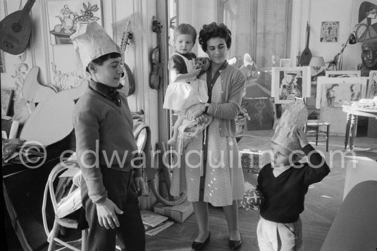 Claude Picasso and Luis Dominguin try on paper hats for size. Inès Sassier with Lucia Dominguin. La Californie, Cannes 1959. - Photo by Edward Quinn