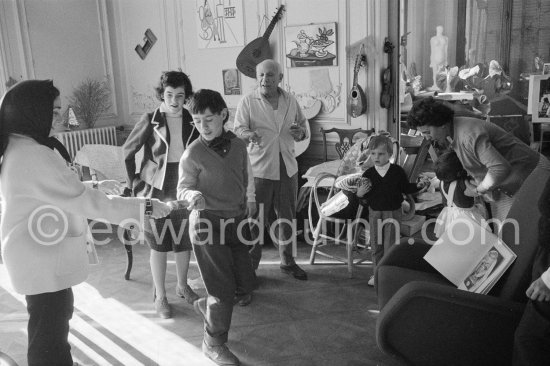 Jacqueline pulls a surprise cracker with Claude Picasso. Behind her daughter Catherine Hutin and Pablo Picasso looking on. Right the Dominguin children with Inès Sassier. La Californie, Cannes 1959. - Photo by Edward Quinn