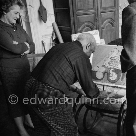 Pablo Picasso signing. Louise Leiris, owner with Daniel-Henry Kahnweiler of the Leiris Gallery Paris, André Weill, publisher of some deluxe editions of Pablo Picasso\'s work, and Paulo Picasso. La Californie, Cannes 1959. - Photo by Edward Quinn