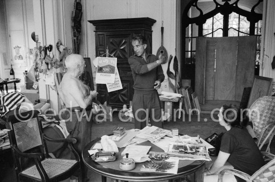Pablo Picasso, David Douglas Duncan and Jacqueline. On the table a pile of English newspapers reporting on his London exhibition. La Californie, Cannes 1960. - Photo by Edward Quinn