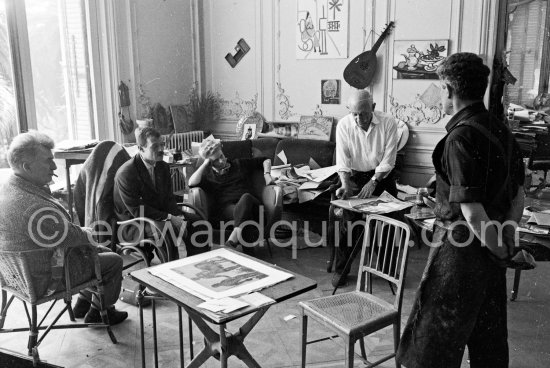 Pablo Picasso working on gouache with Caran d\'ache wax oil pastels and water color. Pablo Picasso always liked surprises and in his work he encouraged unpredictable outcomes. Edouard Pignon, unknown man, Hélène Parmelin, Jacques Frélaut. A table by Joseph-Marius Tiola in the foreground. La Californie, Cannes 1961. - Photo by Edward Quinn