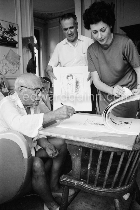 Pablo Picasso signing his lithograph of Rimbaud. With Henri Matarasso and his niece. La Californie, Cannes 1961. - Photo by Edward Quinn