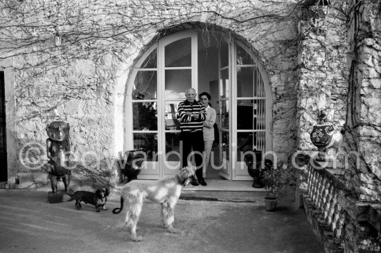 Pablo Picasso and Jacqueline with Afghan dog Kaboul and dachshund Lump on the terrace in front of the entrance to Mas Notre-Dame-de-Vie, Mougins 14.2.1962. - Photo by Edward Quinn